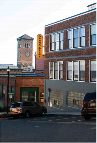 The Ledger Building on Opera Alley in downtown Tacoma, with the Old City Hall clock tower behind it